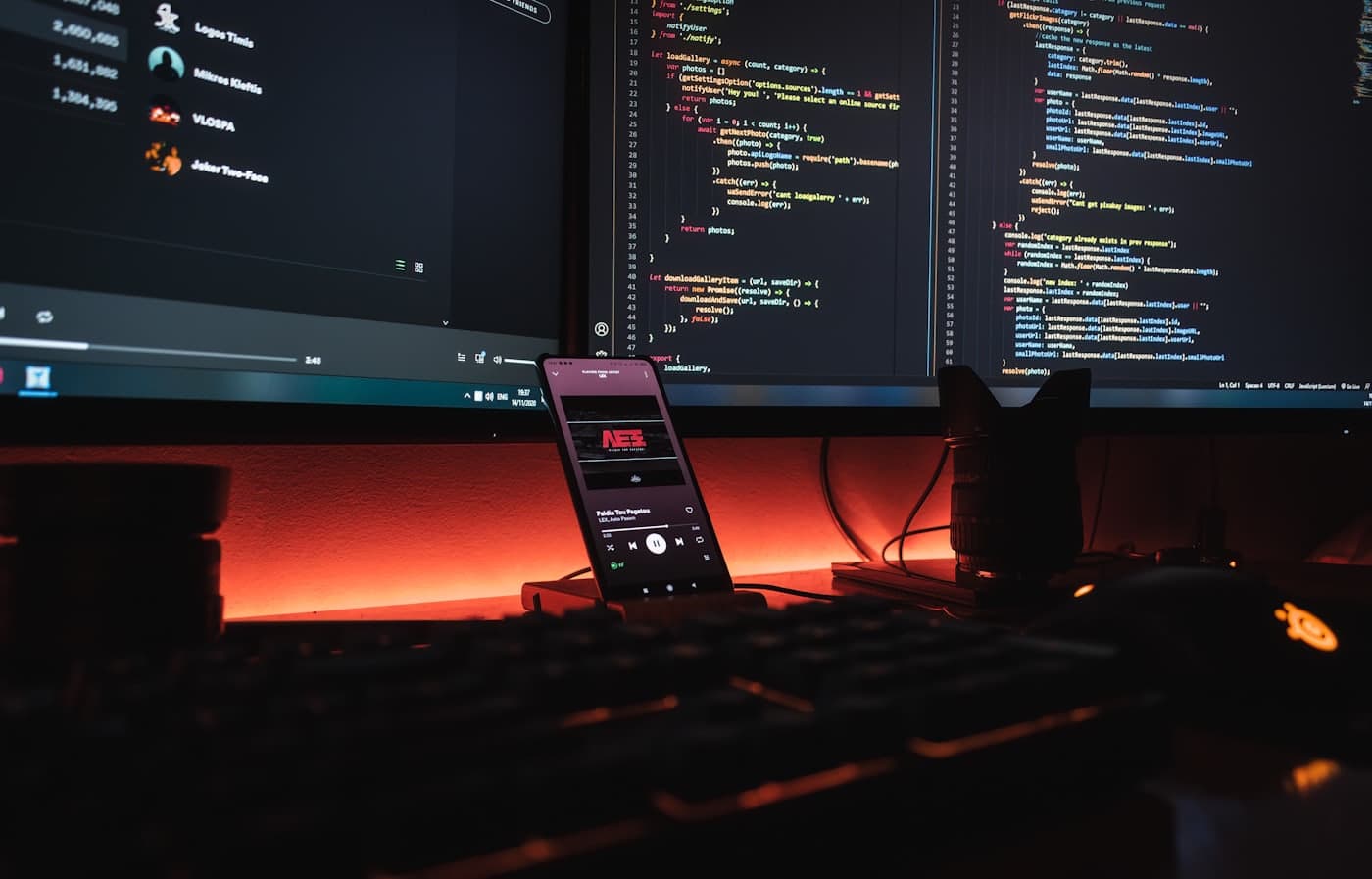 A phone and monitors on a studio desk